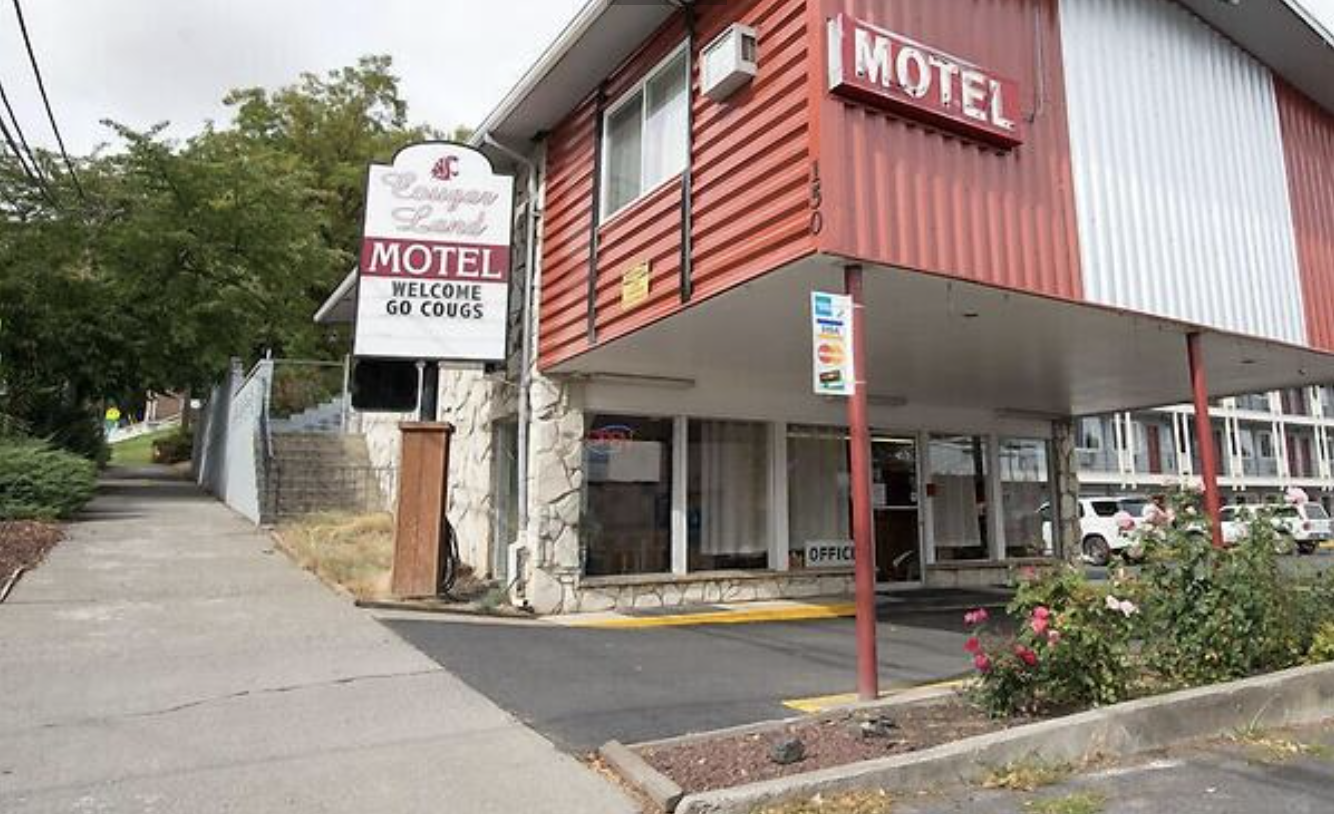 Building with a sign outside that reads Cougar Land Motel, Welcome, go Cougs.